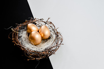 Golden Easter Eggs in birds Nest on black and white abstract background. Easter Holiday concept ...