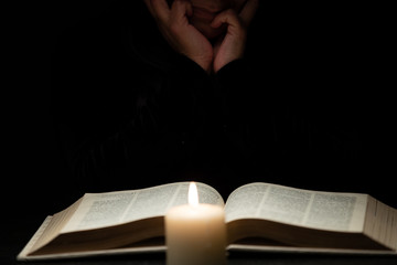 Person Reading Bible by Candle Light