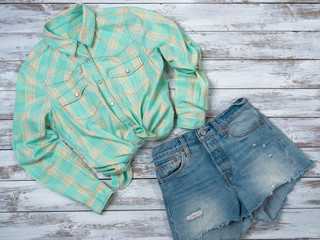 Womens clothing (plaid shirt, denim shorts). Fashion outfit, spring summer collection. Shopping concept. Flat lay, top down view