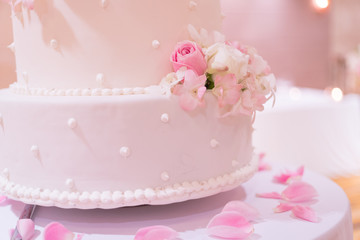 closeup wedding cake in soft pink tone decorate with flower and some petal