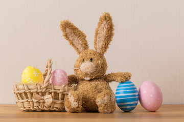 Easter bunny rabbit with  painted egg on wooden background