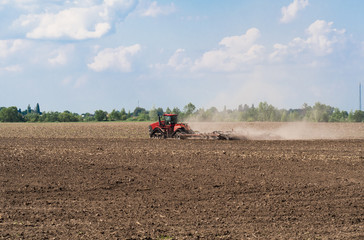 Farmer in tractor preparing land with seedbed cultivator