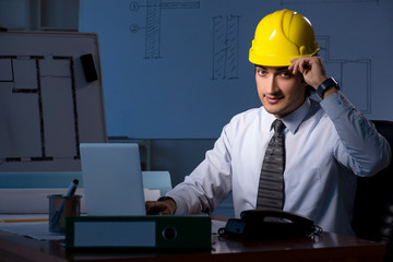 Young construction architect working on project at night 