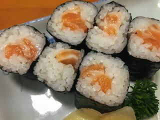 Sushi in the plate on the wood table. Sushi is a type of food preparation originating in Japan.