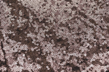 Brown shiny fabric with sequins, abstract background.