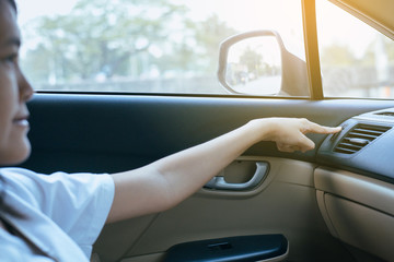 Hand of female turning on car air conditioning system,Button on dashboard in car panel