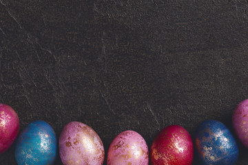 Background of painted colorful Easter eggs with golden spots