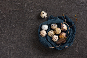 Obraz na płótnie Canvas Nest of fabric with small quail eggs decorated with feather