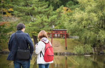 Couple stand beside the lake in Nara Park, Japan