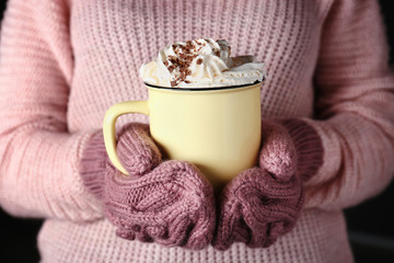 Woman holding cup of hot cacao drink, closeup