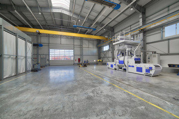 Interior of a modern factory. A bright large workshop, inside there is a shot blasting unit