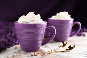 Cups of hot cacao drink on light table