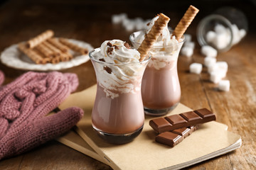 Glasses of hot cacao drink on wooden table