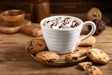 Cup of hot cacao drink with cookies on wooden table