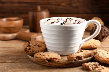 Cup of hot cacao drink with cookies on wooden table
