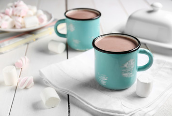 Mug of hot cacao drink with marshmallows on white table