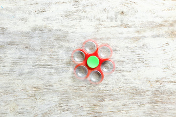 Stroboscopic photo of moving spinner on wooden background