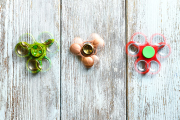 Stroboscopic photo of moving spinners on wooden background