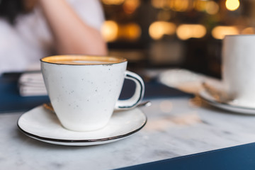 A cup of coffee with latte art in the coffee shop.