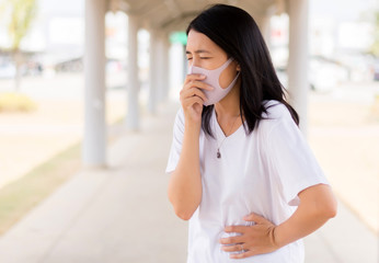 Asian woman using mask protect PM 2.5 because pollution outdoor,Young female got nose allergy