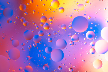 colorful oily drops  in water with colorful background, close-up 