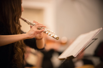 A young woman playing flute at the concert