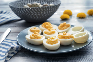 Plate with tasty deviled eggs on wooden table