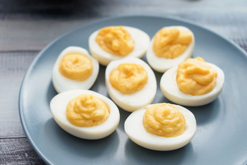 Plate with tasty deviled eggs on table, closeup