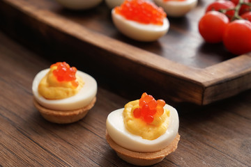 Tasty deviled eggs on wooden table, closeup