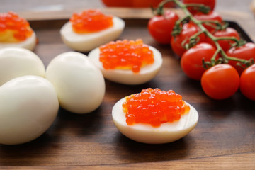 Tasty deviled eggs on wooden board, closeup