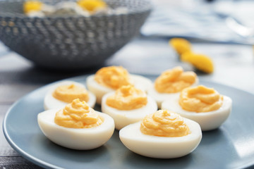 Plate with tasty deviled eggs on table, closeup