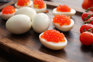 Tasty deviled eggs on wooden board, closeup