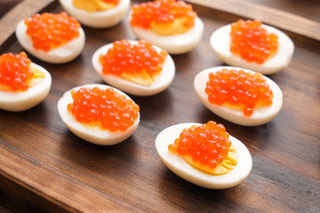 Tasty deviled eggs on wooden board, closeup