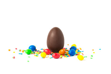 Fototapeta na wymiar Whole Chocolate Easter Egg and multicolored sweets on a white background. Easter celebration concept