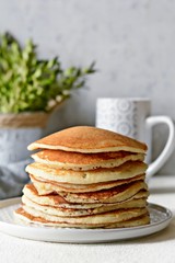 Sweet Homemade Stack of Pancakes with  honey for Breakfast  on a gray background. Sweet beautiful breakfast. Brunch. Family Breakfast. Concept for cafes, restaurants, fast food outlets, bars