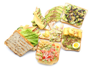 Different tasty sandwiches with avocado on white background