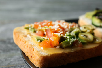Tasty sandwich with avocado on plate, closeup