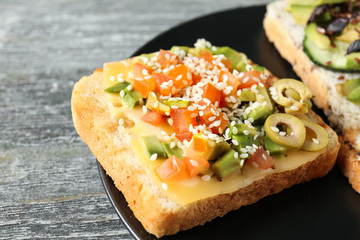 Tasty sandwich with avocado on plate, closeup
