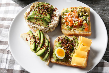 Plate with different tasty sandwiches on table