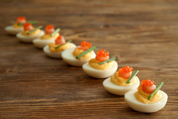 Tasty deviled eggs on wooden table