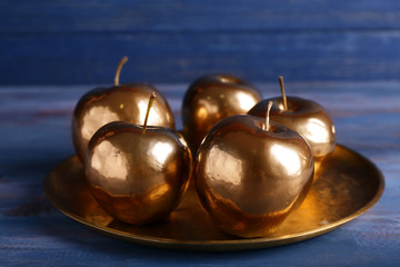 Tray with golden apples on wooden table