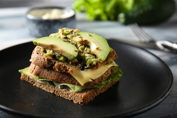 Tasty avocado sandwich on plate, closeup