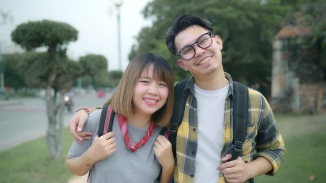 Slow motion - Traveler Asian couple feeling happy smiling to camera holiday trip at Thailand, backpacker sweet couple enjoy their journey at amazing landmark in traditional city.