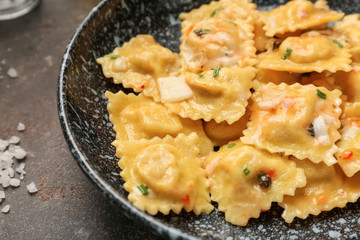 Plate with tasty ravioli on table, closeup