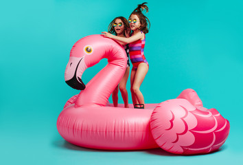 Smiling girls having fun on inflatable toy flamingo © Jacob Lund