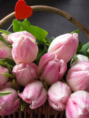 Huge bouquet of pink tulips in wicker basket. Postcard motif, copy space.