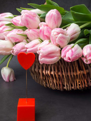 Huge bouquet of pink tulips in wicker basket. Postcard motif, copy space.