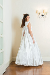 Fototapeta premium Beautiful young bride with curly hair in white wedding dress