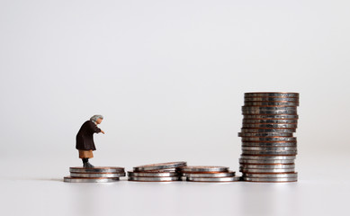 Miniature people and coins. A concept of the continuance of poverty.