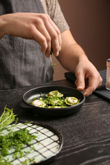Male chef preparing for serving tasty ravioli on table